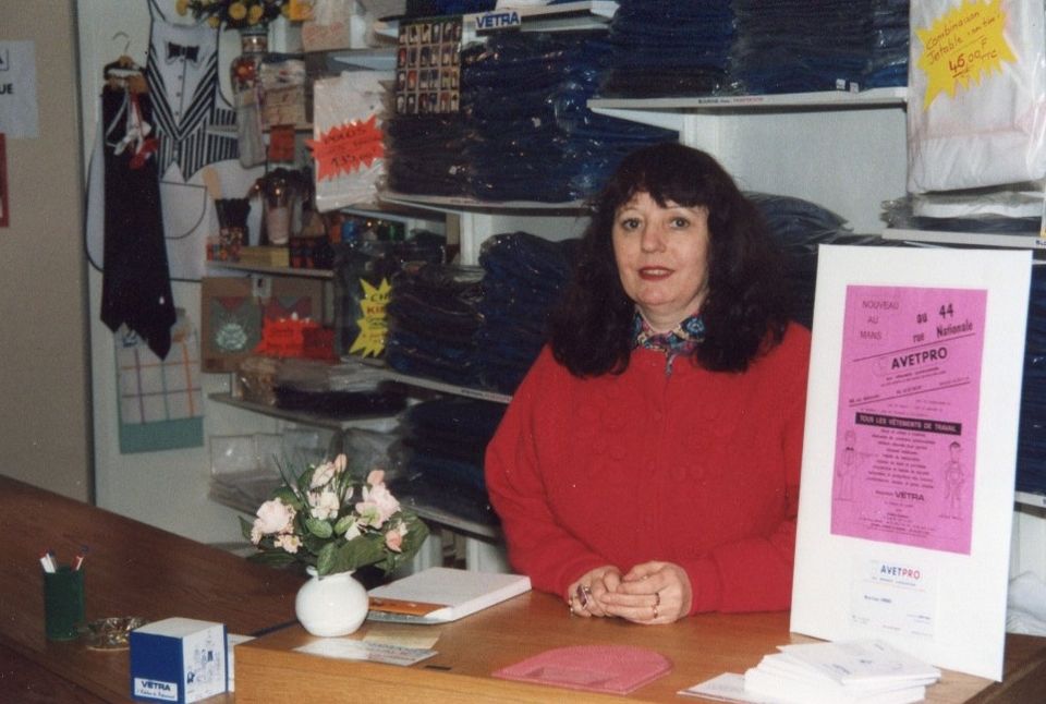 Marie-France Simonel derrière le comptoir de la boutique AVETPRO, devant les rayonnages de vêtements de travail